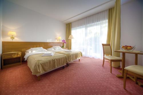 Un pat sau paturi într-o cameră la Két Korona Konferencia és Wellness Hotel