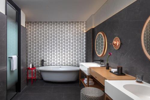 uma casa de banho com uma banheira e um lavatório em Andaz Doha, A Concept by Hyatt em Doha