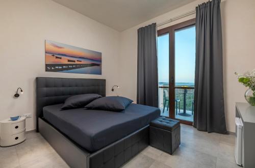 a bedroom with a bed and a large window at Casa B, Room 4 - Palm Kite Paradise in Marsala