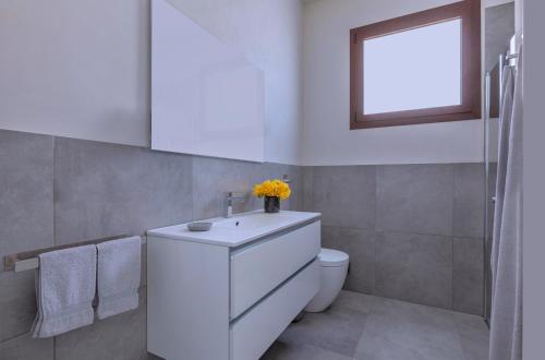 Casa B, Room 4 - Palm Kite Paradise في مارسالا: حمام مع حوض أبيض ومرحاض