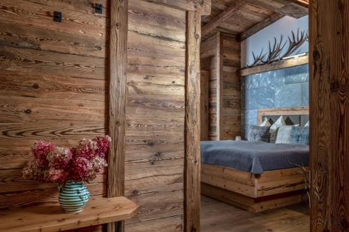 1 dormitorio con 1 cama en una cabaña de madera en Alpengasthof Karalm, en Rauris
