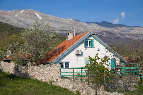 a white house with an orange roof and a fence at Vila Agroturizam Kućica Mostar-Welcome bikers in Mostar