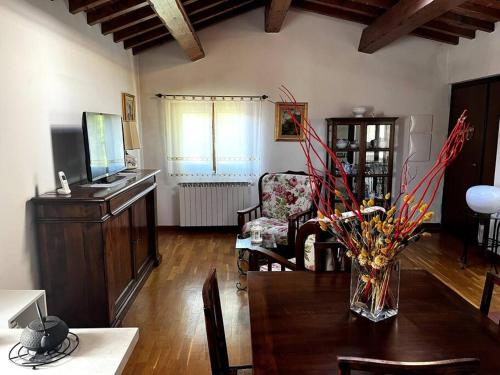 a living room with a table and a chair at Charming Townhouse with Garden in Impruneta