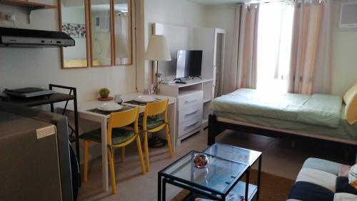 a small living room with a bed and a table at JmR Serin West studio unit pay by Gcash or cash only in Tagaytay