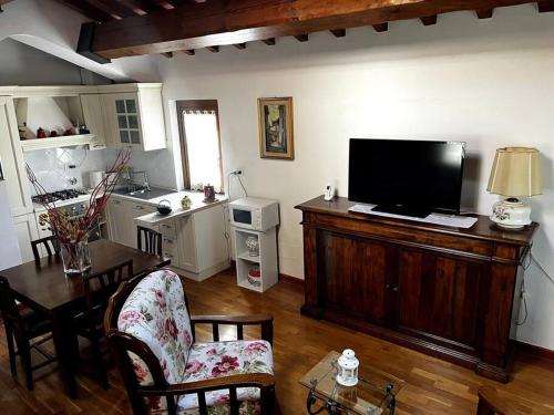 a living room with a television and a table with chairs at Charming Townhouse with Garden in Impruneta