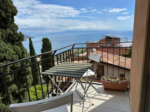 a balcony with a table and a view of the ocean at MIRA taormina rooms in Taormina