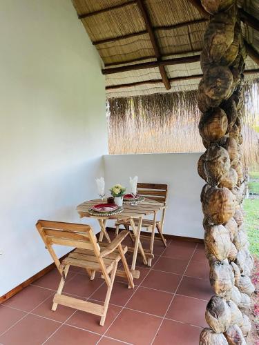 a table and chairs in a room with a stone pillar at Mangal Beach Lodge in Vilanculos