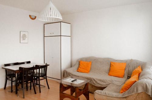 uma sala de estar com um sofá e uma mesa em Apartament Fileo em Koszalin