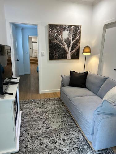 a living room with a blue couch and a television at Hunchy Hideaway in Montville