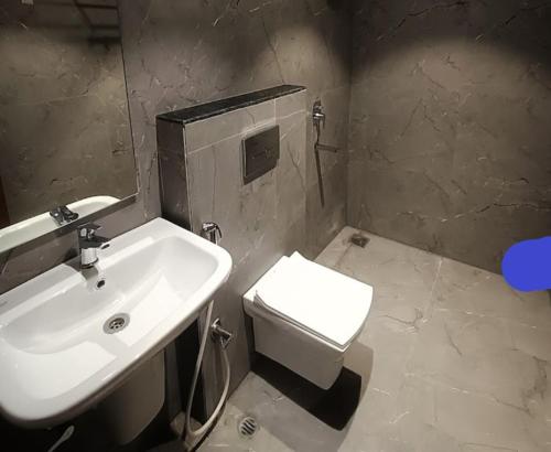 a bathroom with a white sink and a toilet at STAYMAKER Hotel Mohan Palace in Baharampur