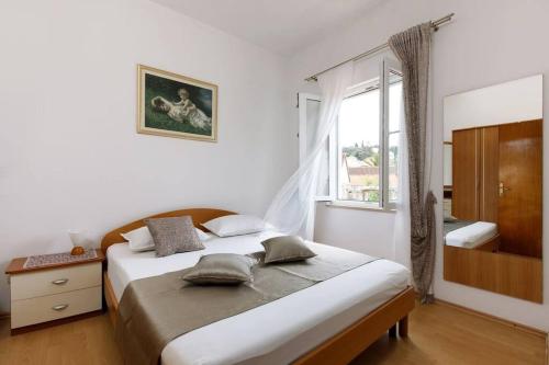 a bedroom with a large bed and a window at Apartment Della Croce in Sutivan