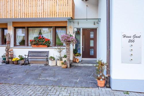 a building with a bench and flowers in front of it at Haus Gant in Sankt Gallenkirch