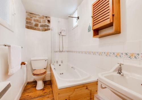 een witte badkamer met een toilet en een wastafel bij Heather View in Gunnerside