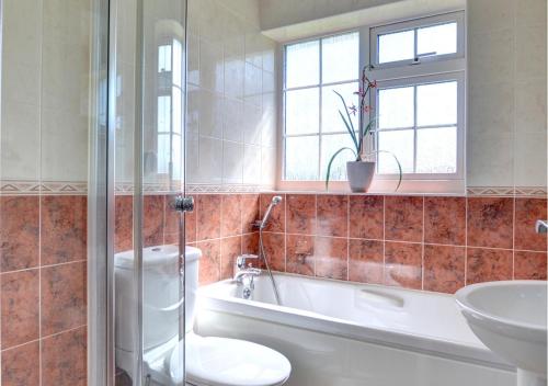 a bathroom with a tub and a toilet and a sink at Heather House in Whitby