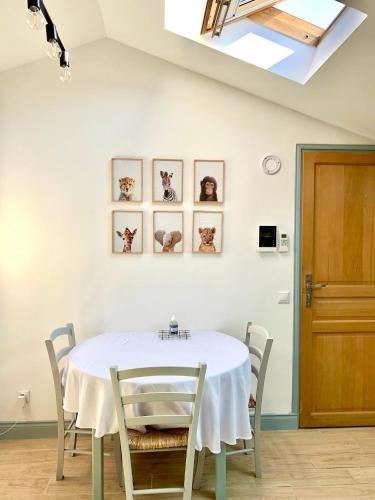 une salle à manger avec une table et des chaises blanches dans l'établissement Safari apartment in heart of Cannes and beaches, à Cannes