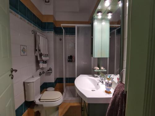 a bathroom with a sink and a toilet and a mirror at Evaggelia's Seaside Boutique Apartment in Iraion