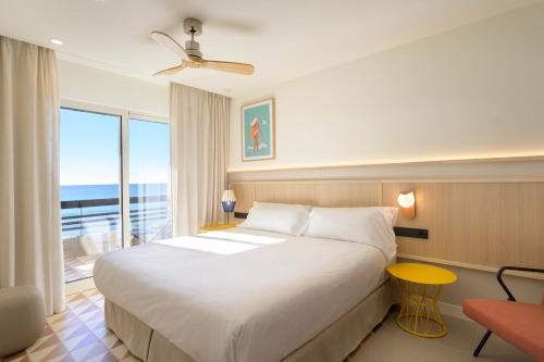 a bedroom with a large bed with a view of the ocean at Akquaaa Boutique Hotel in Calafell