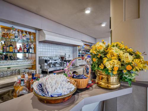 a kitchen with flowers and baskets on a counter at Hotel Cristina in Limone sul Garda
