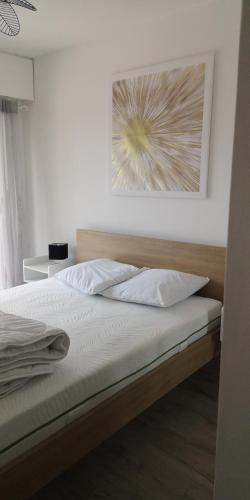 une chambre avec un lit avec un tableau sur le mur dans l'établissement Emplacement exceptionnel / Vue Etang de Vannes, à Vannes