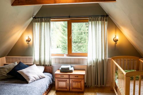 a bedroom with a bed and a window at Brīvdienu māja Vējiņi in Straupe