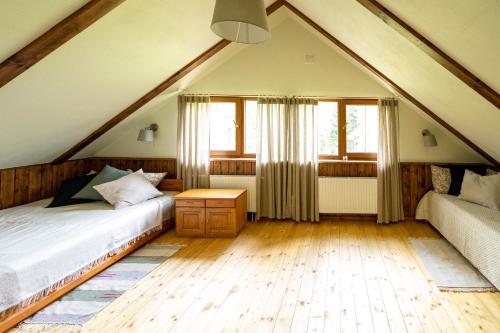 a attic bedroom with a bed and a couch at Brīvdienu māja Vējiņi in Straupe