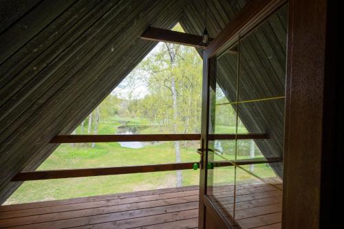a view from the inside of a cabin with a large window at Brīvdienu māja Vējiņi in Straupe