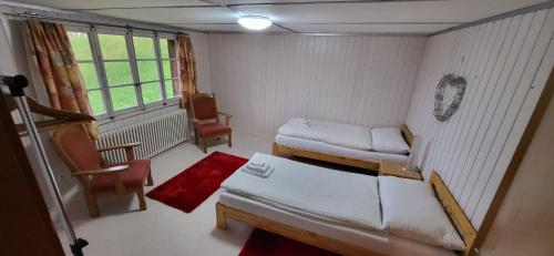 a small room with two beds and a window at Cosy Traditional Swiss Chalet in Wengen