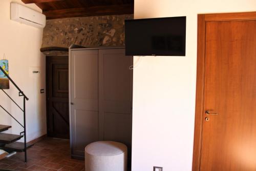 a living room with a television on a wall at Roba Albanisi in Aragona