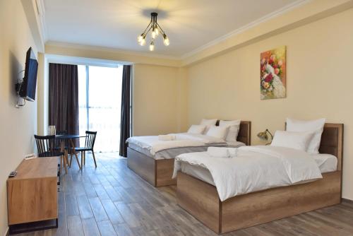 a hotel room with two beds and a table at Altunyan Hotel in Yerevan