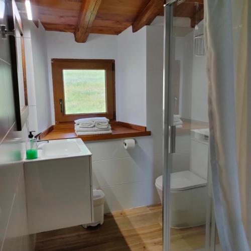 a bathroom with a sink and a toilet and a window at Invernal de Tobaño in Cahecho