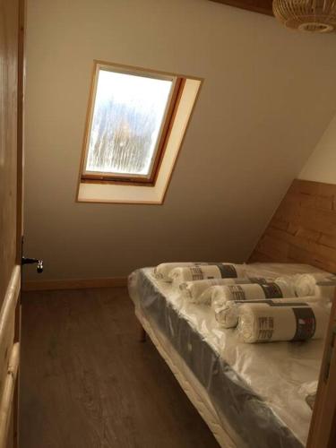 Cette chambre mansardée comprend un lit et une fenêtre. dans l'établissement Appartement Val Louron 6 à 8 personnes, à Génos