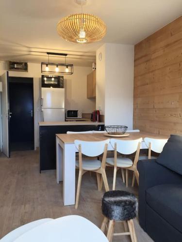 une cuisine et un salon avec une table et un canapé dans l'établissement Appartement Val Louron 6 à 8 personnes, à Génos