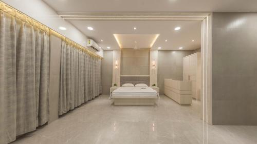 a bedroom with a bed in a room with curtains at The Arowana Divine in Nānded