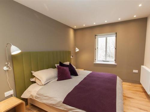a bedroom with a large bed and a window at Sunny Brow Hayloft in Ambleside
