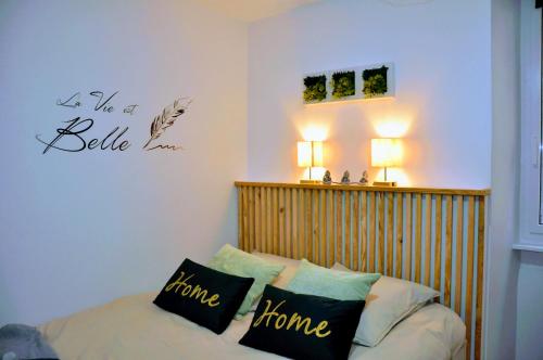 a bedroom with a bed with a wooden head board at Dormir à Brioude - appartement 'esprit zen' in Brioude