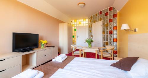 a bedroom with a bed and a tv and a table at Ledan in Chłopy