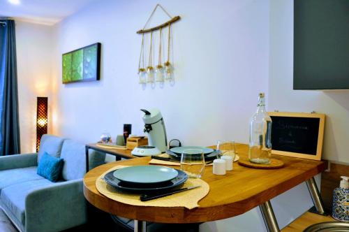 uma sala de estar com uma mesa e um sofá azul em Dormir à Brioude - appartement 'esprit zen' em Brioude