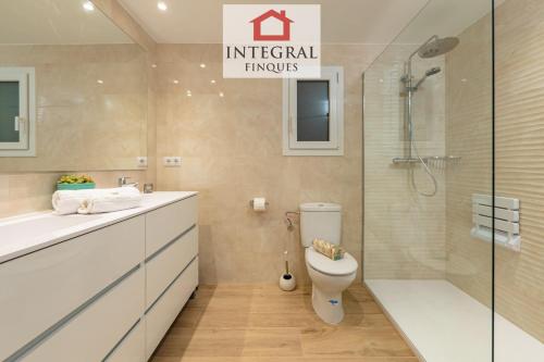 a bathroom with a toilet and a glass shower at Torre Marina Apartments in Calonge