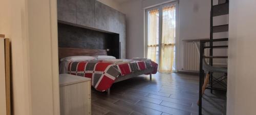 a bedroom with a bed with a red and white blanket at Casa Roma in Piacenza