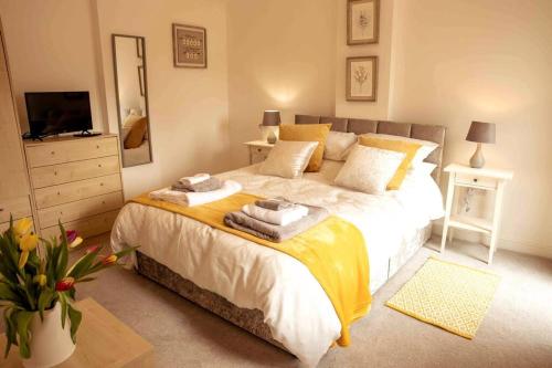1 dormitorio con 1 cama grande y toallas. en The Coach House - Raskelf - YO61 3LD, 