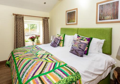 a bedroom with a large bed with a green headboard at Frog House in Reeth
