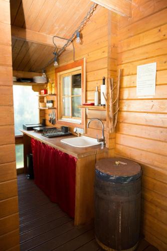 a kitchen with a sink in a log cabin at Avar puhkekompleks saunaga in Kuusiku