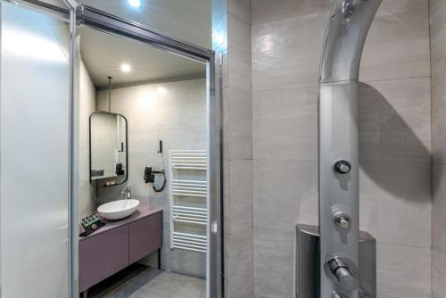 a bathroom with a shower with a sink and a mirror at BED in Athens in Athens