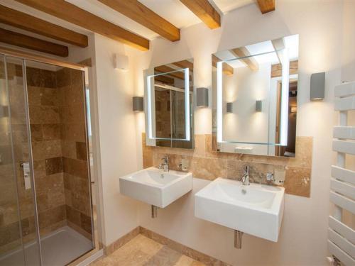 uma casa de banho com 2 lavatórios e um chuveiro em Bracken Barn em Ambleside