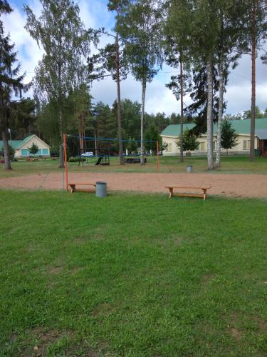 two benches in a park with a playground at Puhkekeskus SUVI in Karjamaa