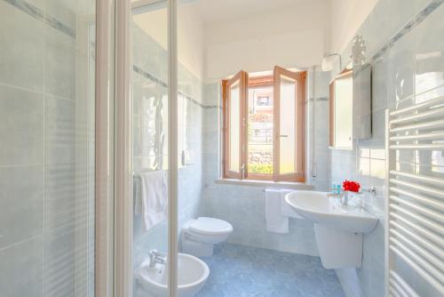 a white bathroom with a toilet and a sink at Villa Due Leoni - Residence in Brenzone sul Garda