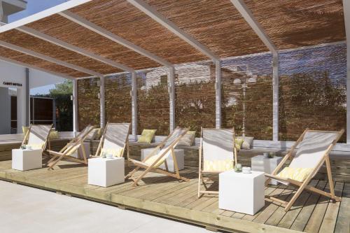 a group of chairs and tables on a deck at Cabot Romantic- Adults Only in Port de Pollensa