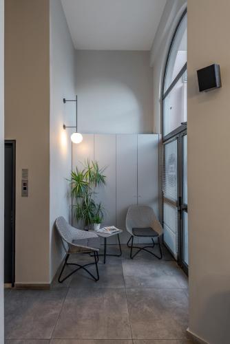 a room with two chairs and a table and a plant at BED in Athens in Athens