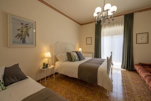 a bedroom with two beds and a window at Etna Sicilian House in Linguaglossa