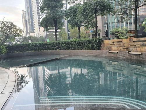 a swimming pool in a city with buildings at BGC Loft in Avant, stunning golf view! in Manila